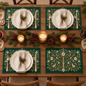 May include: A dining table setting featuring four dark green placemats with a botanical print of rabbits, birds, flowers, and pinecones. Each place setting includes a white plate, a beige napkin with a sprig of greenery, and silver cutlery.