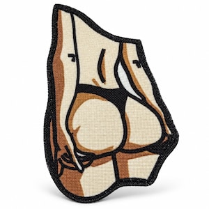 Puede incluir: Un parche de tela con una ilustración gráfica de la parte baja de la espalda y los glúteos de una persona con ropa interior negra. El diseño utiliza tonos beige, marrón y negro con un borde bordado grueso y negro que perfila la forma.