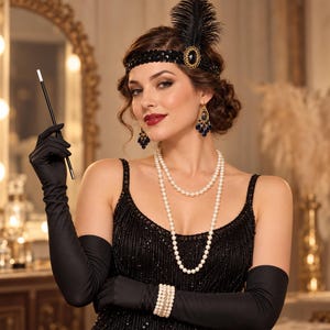 May include: A black sequined dress with long black satin gloves, a black feathered headband with a gold-tone oval accent, a double-strand white pearl necklace, blue drop earrings, and a long black cigarette holder with a white tip.