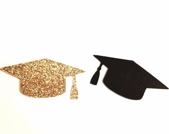 Op de afbeelding: Twee afstudeerhoeden, een met gouden glitter en een zwarte, op een witte achtergrond.