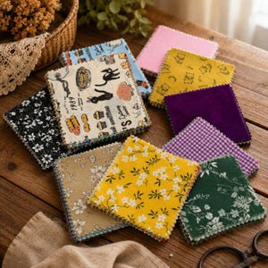 Puede incluir: Una colección de muestras de tela cuadradas con varios patrones, incluyendo estampados florales, cuadros vichy, colores sólidos y una pieza color crema con ilustraciones de gatos negros y el texto 1989 y muffins. Cada pieza tiene bordes dentados.