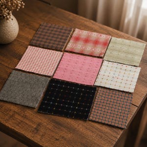 May include: A collection of nine square fabric coasters arranged in a three-by-three grid. The coasters feature various patterns including brown geometric prints, red plaid, sage green stripes, pink gingham, solid pink, white grid, gray tweed, black grid, and multicolored plaid.