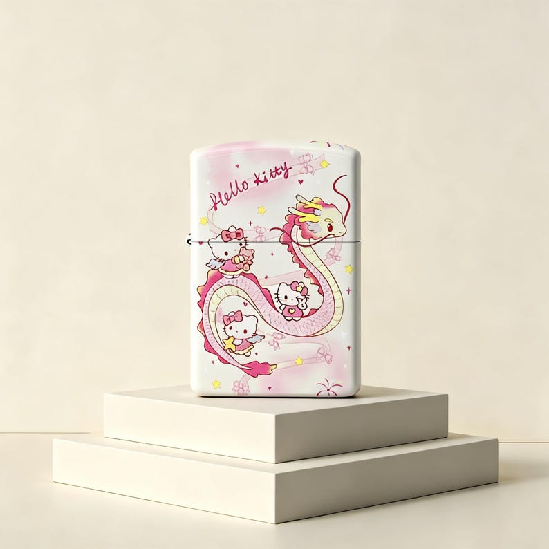 May include: A rectangular metal lighter featuring a light pink and white gradient background with the text Hello Kitty in cursive. The design includes a long, winding pink dragon and three small Hello Kitty characters with wings and stars.