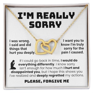Könnte beinhalten: Eine goldfarbene Halskette mit zwei ineinandergreifenden Herzanhängern auf einer weißen Karte. Die Karte enthält den schwarzen Text I'M REALLY SORRY, I was wrong. I said and did things that hurt you deeply. I want you to know I'm truly sorry for the pain I caused. If I could go back in time, I would do everything differently. I know sorry isn't enough for how much I hurt and disappointed you, but I hope this shows you I've realized and deeply regretted my actions. PLEASE, FORGIVE ME.