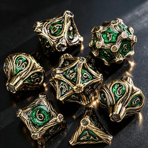 May include: A set of seven polyhedral dice featuring an antique gold-toned metal finish with intricate, branch-like raised textures and vibrant green enamel inlays. Each die displays clear, embossed numbers across its various geometric faces.