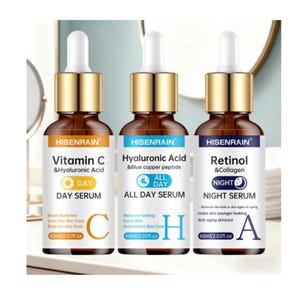 May include: Three amber glass dropper bottles labeled HISENRAIN. The left bottle is a Vitamin C & Hyaluronic Acid Day Serum, the center is a Hyaluronic Acid & Blue Copper Peptide All Day Serum, and the right is a Retinol & Collagen Night Serum.