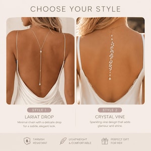 K&ouml;nnte beinhalten: Zwei R&uuml;ckenhalsketten auf einem wei&szlig;en Kleid. Stil 1 ist eine Lariat-Kette mit einer d&uuml;nnen Kette und einem einzelnen Kristallanh&auml;nger. Stil 2 ist eine Kristall-Rankenkette mit einer vertikalen Anordnung aus marquise- und rundgeschliffenen Kristallen.