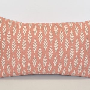 May include: A rectangular pink pillow with a white leaf pattern.