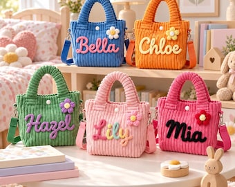 May include: Five small corduroy tote bags in blue, orange, green, light pink, and dark pink. Each bag features a white button closure, a small crocheted flower, and a personalized name in raised lettering: Bella, Chloe, Hazel, Lily, and Mia.