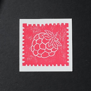 May include: A square print featuring a white outline of a raspberry with leaves centered on a vibrant pink background. The pink area has a textured, stamped appearance and is bordered by a white scalloped edge resembling a postage stamp.