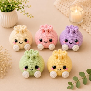May include: Five small, round, crocheted plush toys in pastel yellow, pink, lavender, light green, and bright yellow. Each toy features a gathered top, two black bead eyes, a stitched smile, pink blush marks, and two small white feet.