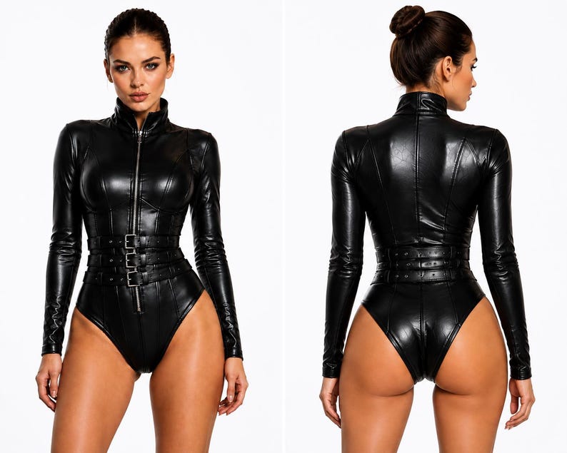 May include: A black long-sleeved bodysuit made of a shiny faux leather material. The garment features a high collar, a full-length front zipper, and three horizontal buckled straps around the waist. The design includes vertical seam detailing.