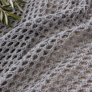 Close up of grey open mesh crochet stitch made with double crochet and chain spaces, beginner mesh top pattern