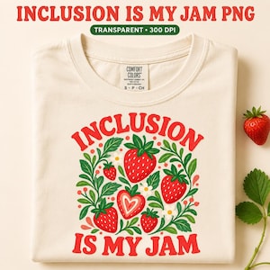 Pode incluir: Uma t-shirt cor de creme com um gráfico de morangos vermelhos, folhas verdes e flores brancas. O texto "INCLUSION IS MY JAM" está impresso a vermelho acima e abaixo da ilustração dos morangos. A t-shirt tem uma etiqueta Comfort Colors.