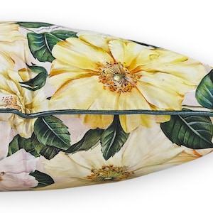 Peut inclure: Un coussin rectangulaire orn&eacute; d'un imprim&eacute; botanique d&eacute;taill&eacute; repr&eacute;sentant de grandes fleurs jaune p&acirc;le et des feuilles vert fonc&eacute; sur un fond clair. Le coussin est fini avec un passepoil vert fonc&eacute; le long de la couture lat&eacute;rale.