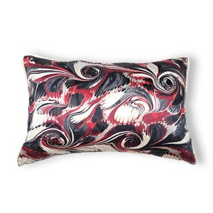 Puede incluir: Un coj&iacute;n rectangular con un patr&oacute;n jaspeado de colores arremolinados en rojo intenso, negro, blanco y gris. La tela muestra formas fluidas y org&aacute;nicas que crean un dise&ntilde;o abstracto y continuo en toda la superficie del coj&iacute;n decorativo.