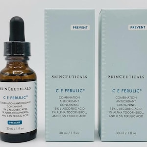 May include: A brown glass dropper bottle and two light blue rectangular boxes of SkinCeuticals C E Ferulic combination antioxidant serum. Each label and box displays the text: 15% L-Ascorbic Acid, 1% Alpha Tocopherol, and 0.5% Ferulic Acid, 30 ml / 1 fl oz.