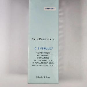 May include: A rectangular light blue SkinCeuticals C E Ferulic skincare product box. The text reads: PREVENT, SKINCEUTICALS, C E FERULIC, COMBINATION ANTIOXIDANT CONTAINING 15% L-ASCORBIC ACID, 1% ALPHA TOCOPHEROL, AND 0.5% FERULIC ACID, 30 ml / 1 fl oz.