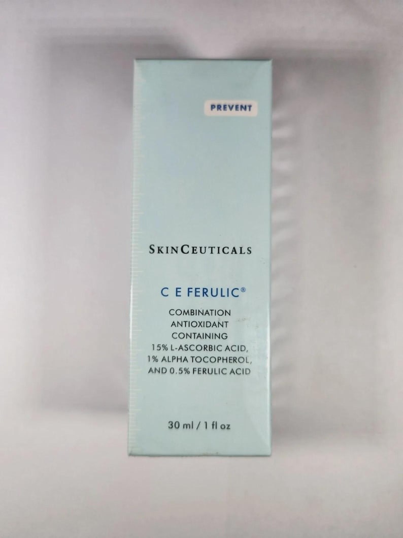 May include: A rectangular light blue SkinCeuticals C E Ferulic skincare product box. The text reads: PREVENT, SKINCEUTICALS, C E FERULIC, COMBINATION ANTIOXIDANT CONTAINING 15% L-ASCORBIC ACID, 1% ALPHA TOCOPHEROL, AND 0.5% FERULIC ACID, 30 ml / 1 fl oz.