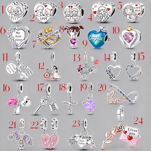May include: A collection of twenty-four silver-toned metal charms featuring various designs including hearts, figures, flowers, bicycles, crosses, and keys, with some charms accented by colourful enamel, crystals, and engraved text like Love Mom and I love you.
