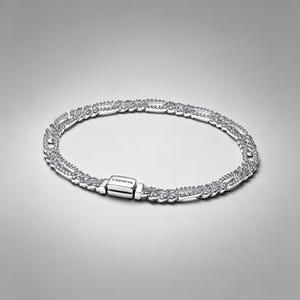 May include: A silver-toned chain bracelet featuring a series of interlocking rectangular links, each embedded with small clear stones. The bracelet includes a rectangular clasp engraved with the brand name Pandora in a clean, sans-serif font.