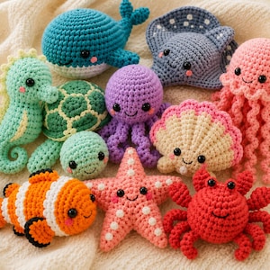 Puede incluir: Una colección de diez criaturas marinas tejidas a ganchillo que incluye una ballena azul, una raya gris, una medusa rosa, un caballito de mar verde, una tortuga verde, una pequeña bola verde, un pulpo morado, una concha beige, un pez payaso naranja y un cangrejo rojo.