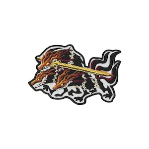 May include: An embroidered patch featuring a three-headed wolf creature with black, white, and dark red fur. The creature has glowing yellow eyes and sharp teeth, with a long, golden sword held across its heads and silver chains draped around its necks.