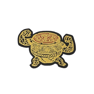 Op de afbeelding: Een geborduurde patch met een goudkleurige antropomorfe trommel met gespierde armen en benen. Het trommellichaam vertoont ingewikkelde wervelpatronen in gouddraad, terwijl het bovenoppervlak een geometrisch ontwerp in rood en goud toont.