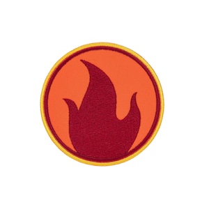 Può includere: Una toppa ricamata circolare con una grafica a fiamma rosso scuro centrata su uno sfondo arancione brillante. Il design è racchiuso da un sottile bordo interno rosso scuro e da un bordo esterno giallo più spesso, creando un emblema circolare.
