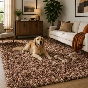 Puede incluir: Una alfombra rectangular de pelo largo y grueso con una paleta de colores variados en tonos marrón, beige, crema y rosa suave. La alfombra presenta una superficie densa y texturizada, proporcionando una base suave sobre el suelo.