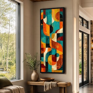 May include: A tall, rectangular wall art piece featuring a vibrant abstract composition of interlocking curved shapes and geometric forms in shades of teal, orange, yellow, black, and cream, enclosed within a thin, dark, minimalist frame.