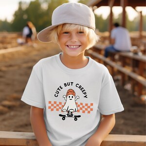 Süß aber gruselig Kinder T-Shirt | Halloween-Geist T-shirt | Skating Ghost Top | Halloween Tshirt für Kinder | Kariertes Skateboard-Design | Skater Kid