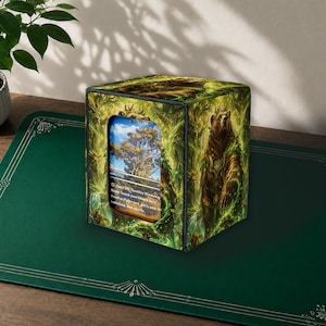Op de afbeelding: Een vierkante deckbox met een bosillustratie en een bruine beer met een kroon. Het voorpaneel heeft een rechthoekige uitsparing die een ruilkaart toont met een landschap en de tekst Pay 1 life, Sacrifice Windswept Heath.