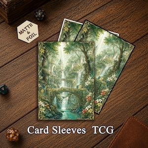 May include: Two rectangular card sleeves featuring a detailed illustration of a lush forest landscape with stone bridges, cascading waterfalls, and white and red flowers. A hexagonal token with the text MATTE & FOIL is visible nearby.