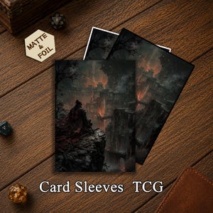 May include: Two rectangular card sleeves featuring a dark fantasy illustration of a cloaked figure overlooking a ruined, fiery landscape. A hexagonal token with the text MATTE & FOIL is visible, along with several multi-sided gaming dice.
