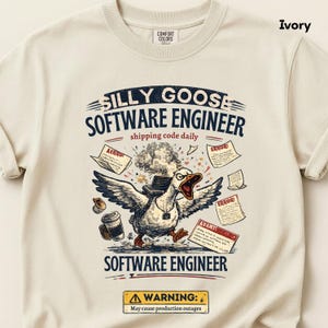 May include: An ivory t-shirt featuring a graphic of a goose with wings spread, wearing a laptop backpack, surrounded by coffee, error messages, and the text SILLY GOOSE SOFTWARE ENGINEER, shipping code daily, and WARNING: May cause production outages.