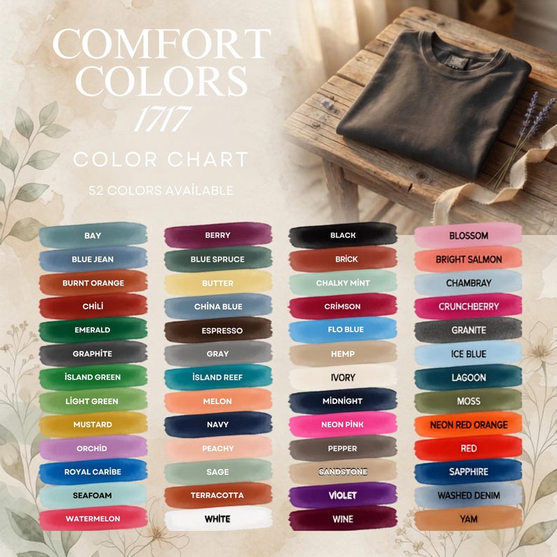 May include: A Comfort Colors 1717 color chart displaying 52 fabric color swatches with names like Bay, Berry, Black, and Blossom. The chart includes a folded black t-shirt on a wooden surface and text reading Comfort Colors 1717 Color Chart.