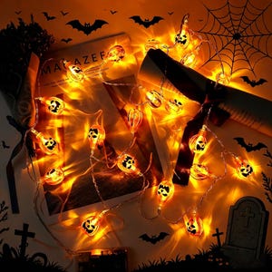 May include: A string of LED lights featuring small, glowing orange pumpkin-shaped covers with black jack-o'-lantern faces. The lights are connected by a thin, flexible wire and emit a warm, bright light, creating a festive Halloween atmosphere.