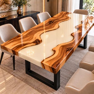 May include: A rectangular dining table featuring a live edge wood slab with a glossy finish and a central white resin river inlay. The table is supported by black metal U-shaped legs and is surrounded by several light gray upholstered chairs.
