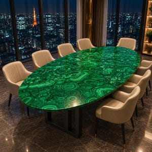 Può includere: Un tavolo da pranzo ovale con un piano in pietra di malachite verde vibrante con intricati motivi concentrici, sostenuto da una base in metallo nero, circondato da otto sedie imbottite color beige con gambe scure in un grattacielo.