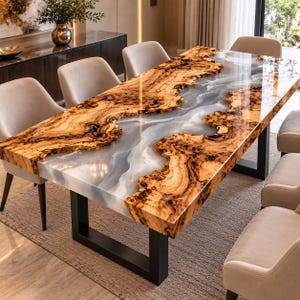 May include: A rectangular dining table featuring a live edge wood slab with a central river of translucent, swirling grey and white resin. The table is supported by black metal U-shaped legs and is surrounded by six light beige upholstered chairs.