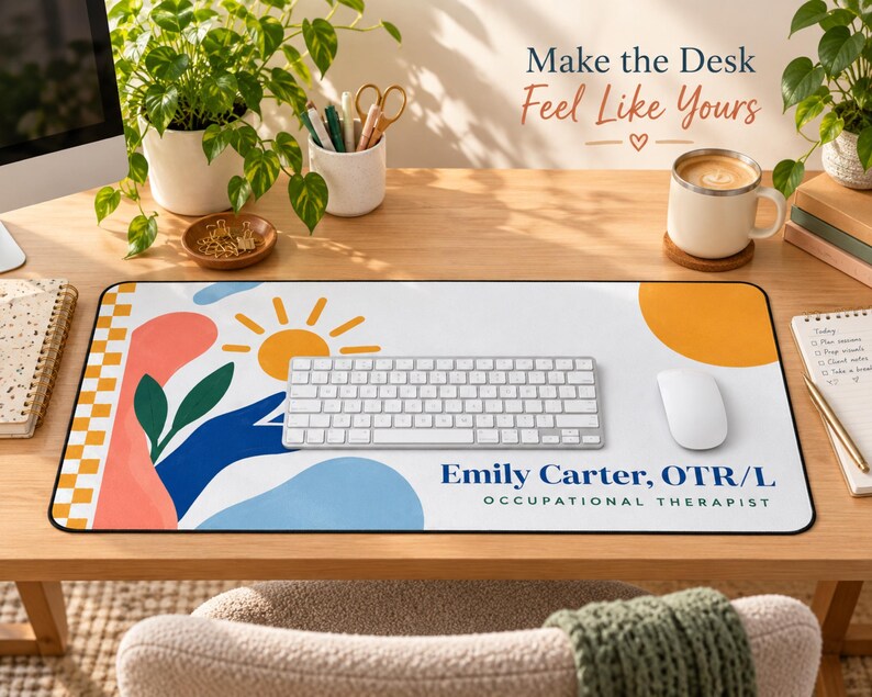Op de afbeelding: Een rechthoekige bureaumat met een witte achtergrond, een gele zon, abstracte blauwe en koraalkleurige vormen en een geblokte rand. De tekst luidt Emily Carter, OTR/L OCCUPATIONAL THERAPIST. Een wit toetsenbord en een muis liggen op de mat.