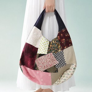 May include: A hobo-style shoulder bag constructed from a patchwork of various fabric squares. The bag features a dark navy blue handle and a diverse mix of patterns including floral prints, polka dots, gingham, and solid maroon and beige panels.