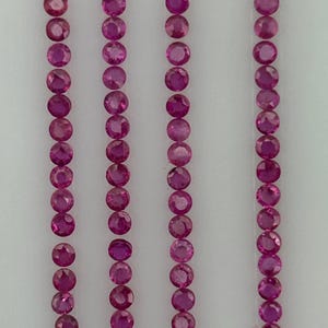 May include: Four vertical rows of small, round, faceted pink gemstones arranged in a linear pattern. Each gemstone displays a brilliant cut with multiple facets that reflect light, creating a consistent, uniform appearance across all four columns.