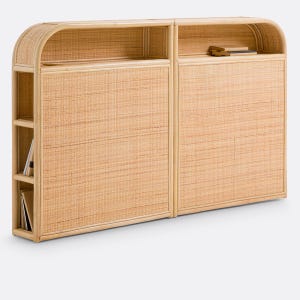 May include: A light tan rattan console table featuring two main sections with woven surfaces, rounded top edges, and an open shelf at the top of each section. The left side includes three vertical side shelves containing books.