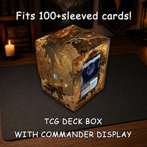 May include: A square TCG deck box with a commander display window, featuring a printed autumn forest scene with a raccoon and a jack-o'-lantern. The box includes the text Fits 100+sleeved cards! TCG DECK BOX WITH COMMANDER DISPLAY.