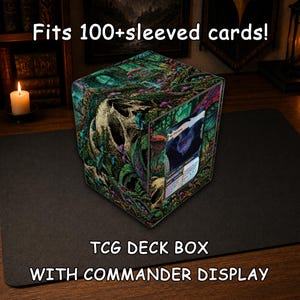 May include: A square TCG deck box with a commander display window, featuring a dark forest graphic with a skull and mushrooms. The text reads: Fits 100+sleeved cards! TCG DECK BOX WITH COMMANDER DISPLAY. The box holds a single trading card.