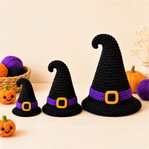 Puede incluir: Tres sombreros de bruja tejidos a ganchillo en color negro de diferentes tamaños, cada uno con una banda morada y una hebilla cuadrada amarilla. Los sombreros tienen una punta ligeramente curvada y ala ancha, con textura de hilo visible.