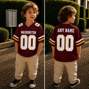 May include: A burgundy football jersey with white and yellow sleeve stripes, featuring the text WASHINGTON and the number 00 on the front, and the text ANY NAME and the number 00 on the back, paired with beige cargo pants and black sneakers.
