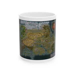 May include: A white ceramic mug featuring a detailed fantasy map printed on its exterior. The map displays various geographical regions including The Frostmarches, The Grand Taiga, The Gordan Plains, The Kingdom of Messaberi, and The Lowmarch Feudal Lands.